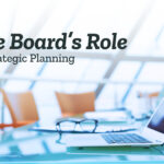 The Board's Role in Strategic Planning. Image shows an empty boardroom table, chairs, and an open laptop.