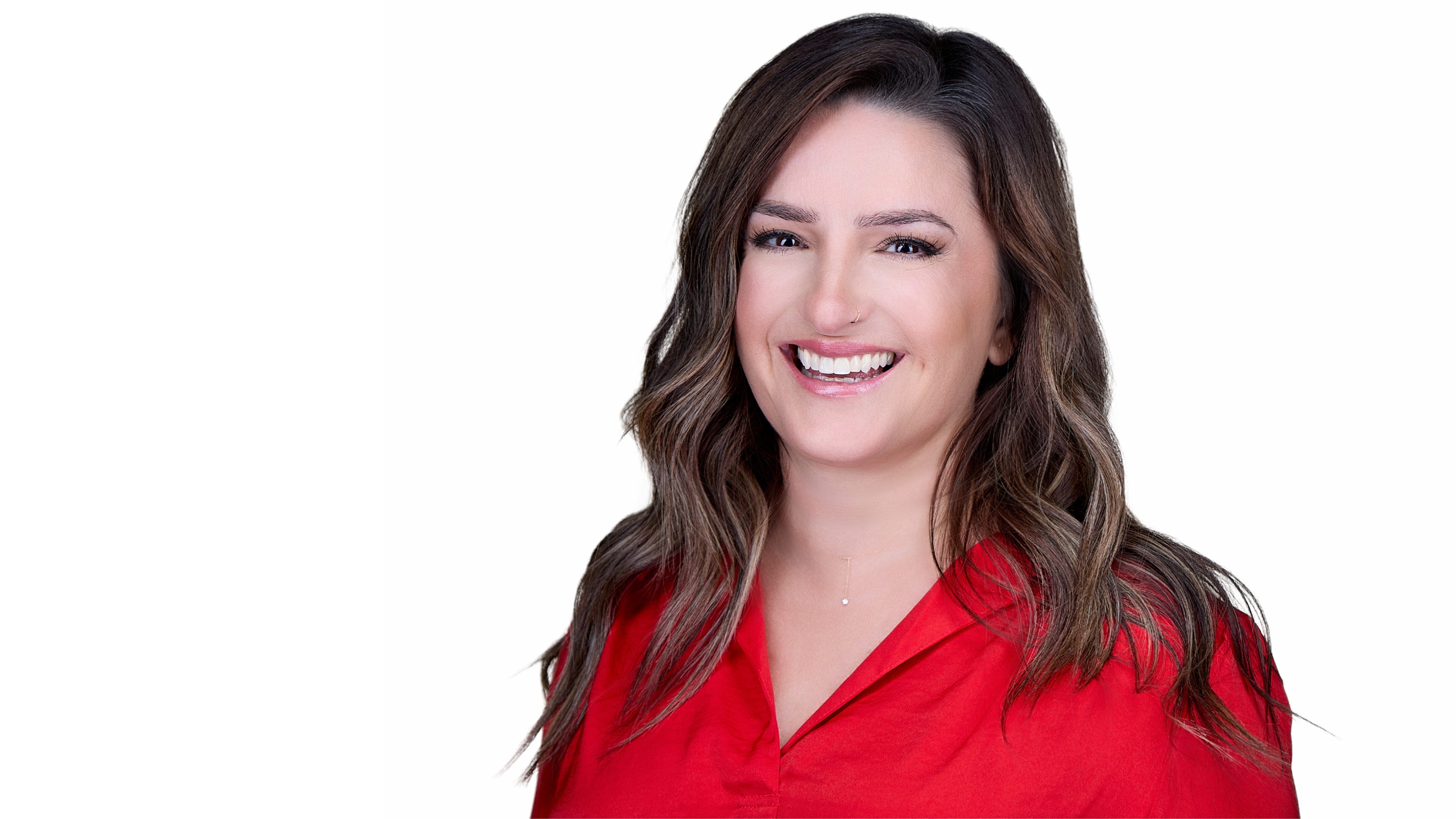 Jerusha has brown hair and is wearing a red shirt. She's smiling in front of a white background.