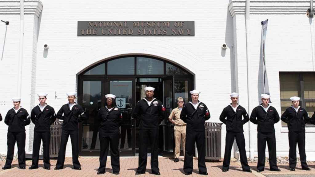 National Museum of the U.S. Navy. Image shows navy members lined up in front of the museum.