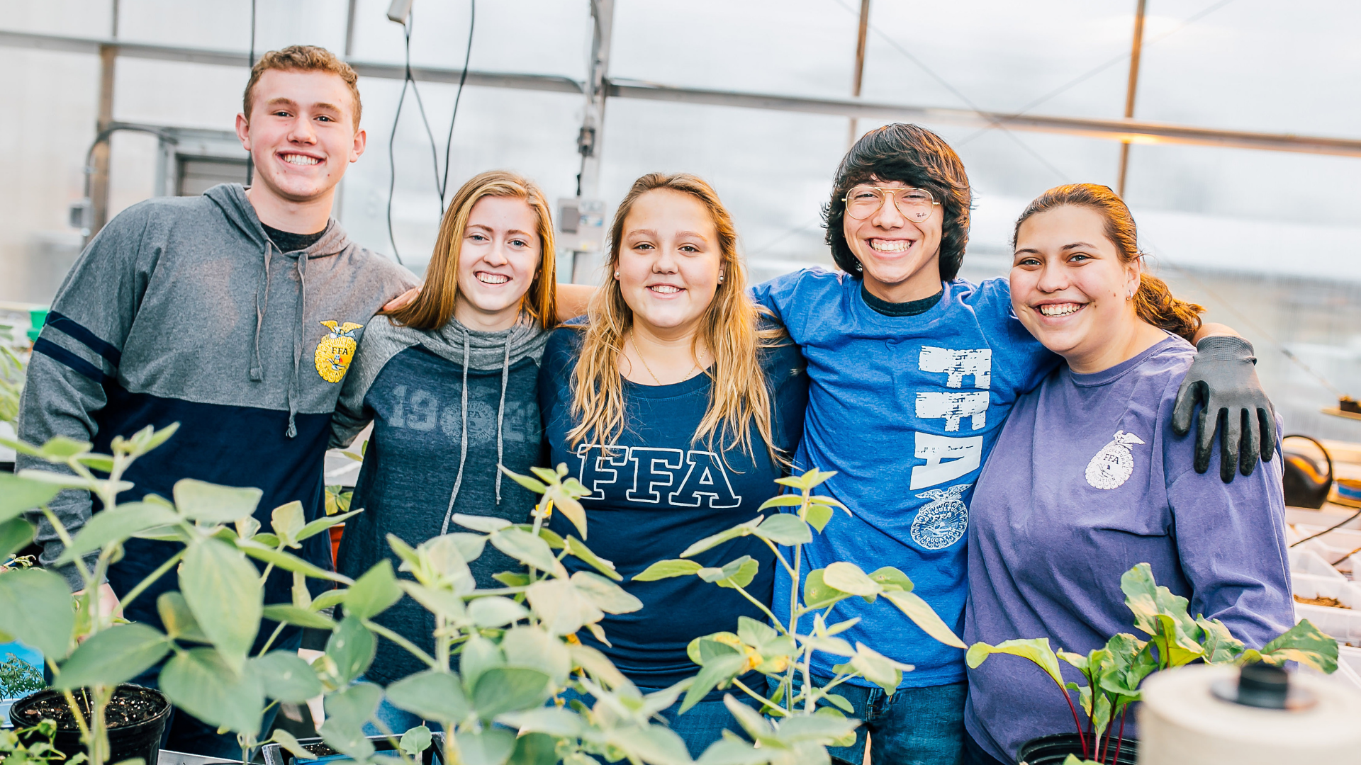 Ohio Future Farmers of America Foundation. Image shows students smiling in a greenhouse.