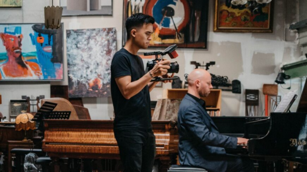 Ohio Humanities. Image shows someone filming while another person is playing the piano.