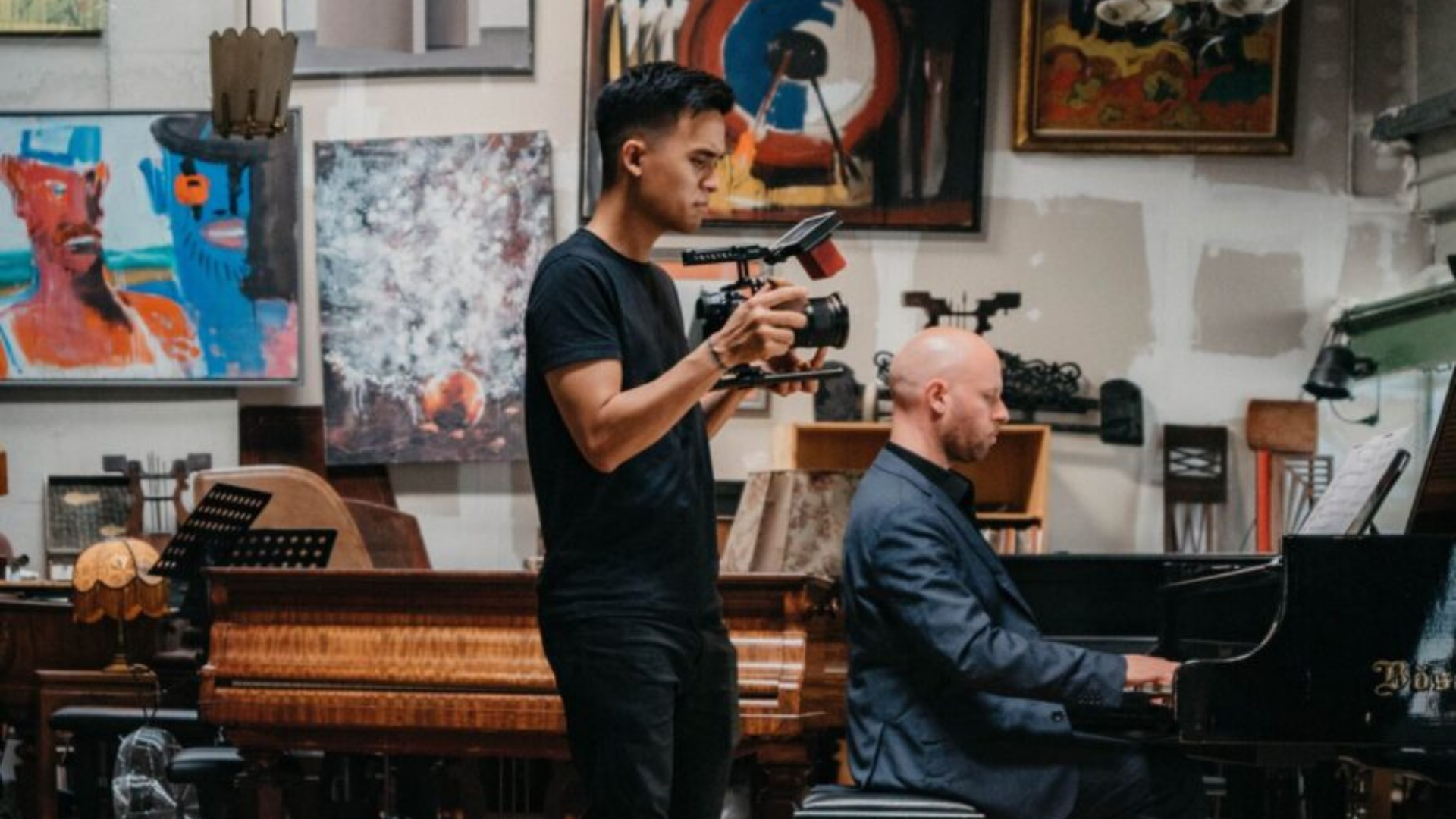 Ohio Humanities. Image shows someone filming while another person is playing the piano.