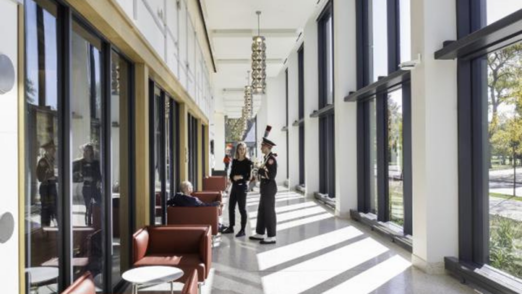 The Ohio State University School of Music. Image shows students talking in a sunny hallway.