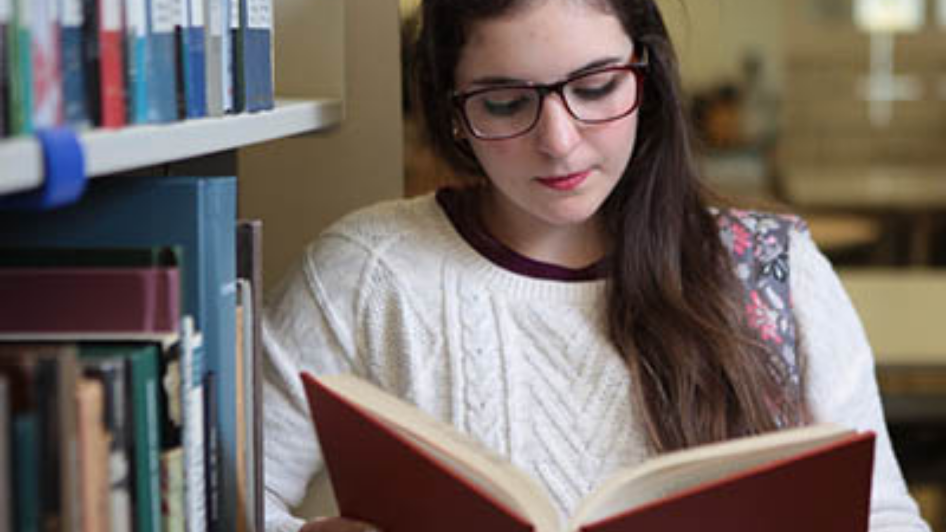 Columbus State Technical and Community College. Image shows student reading a book in the library.