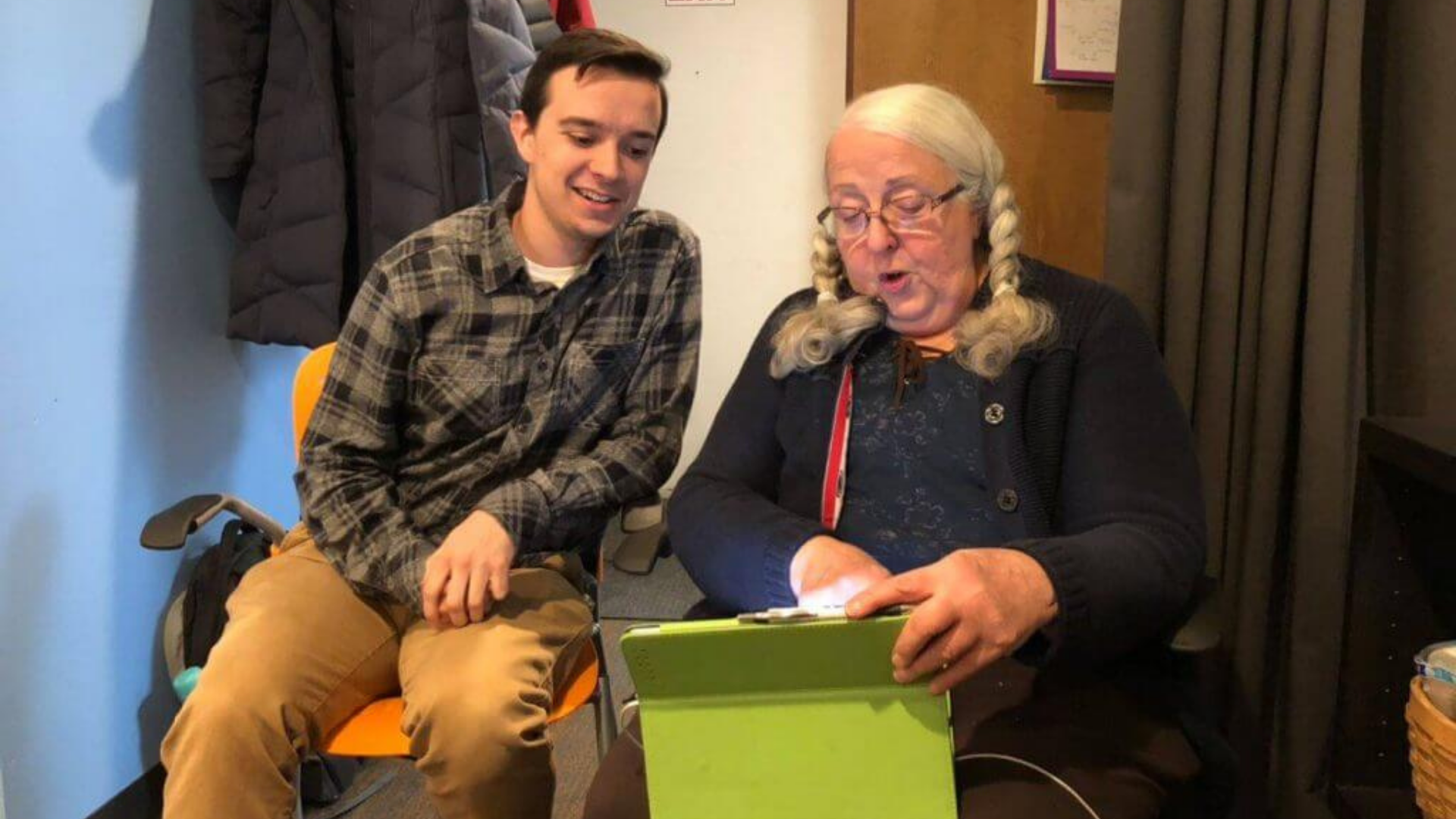 Clintonville-Beechwold Community Resources Center. Image shows one person showing another person something on a tablet.