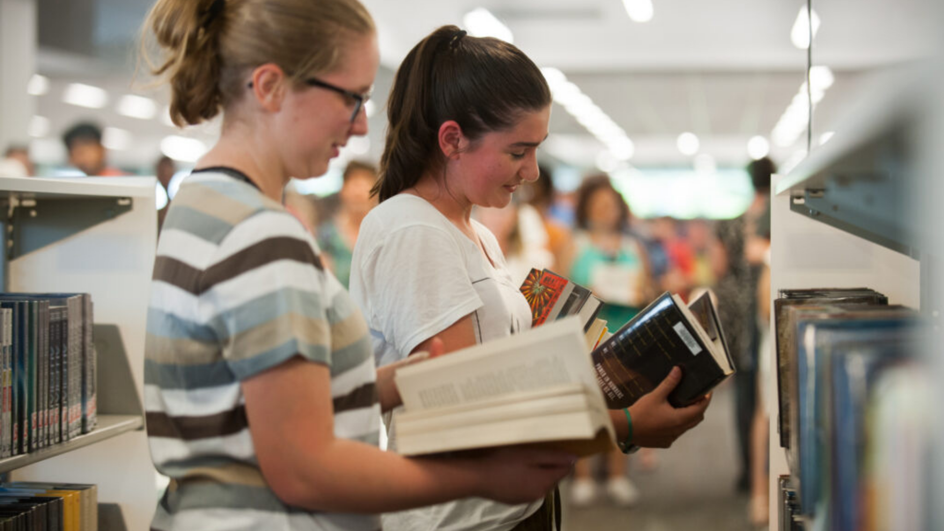 Columbus Metropolitan Library. Image shows two women holding and reading books.
