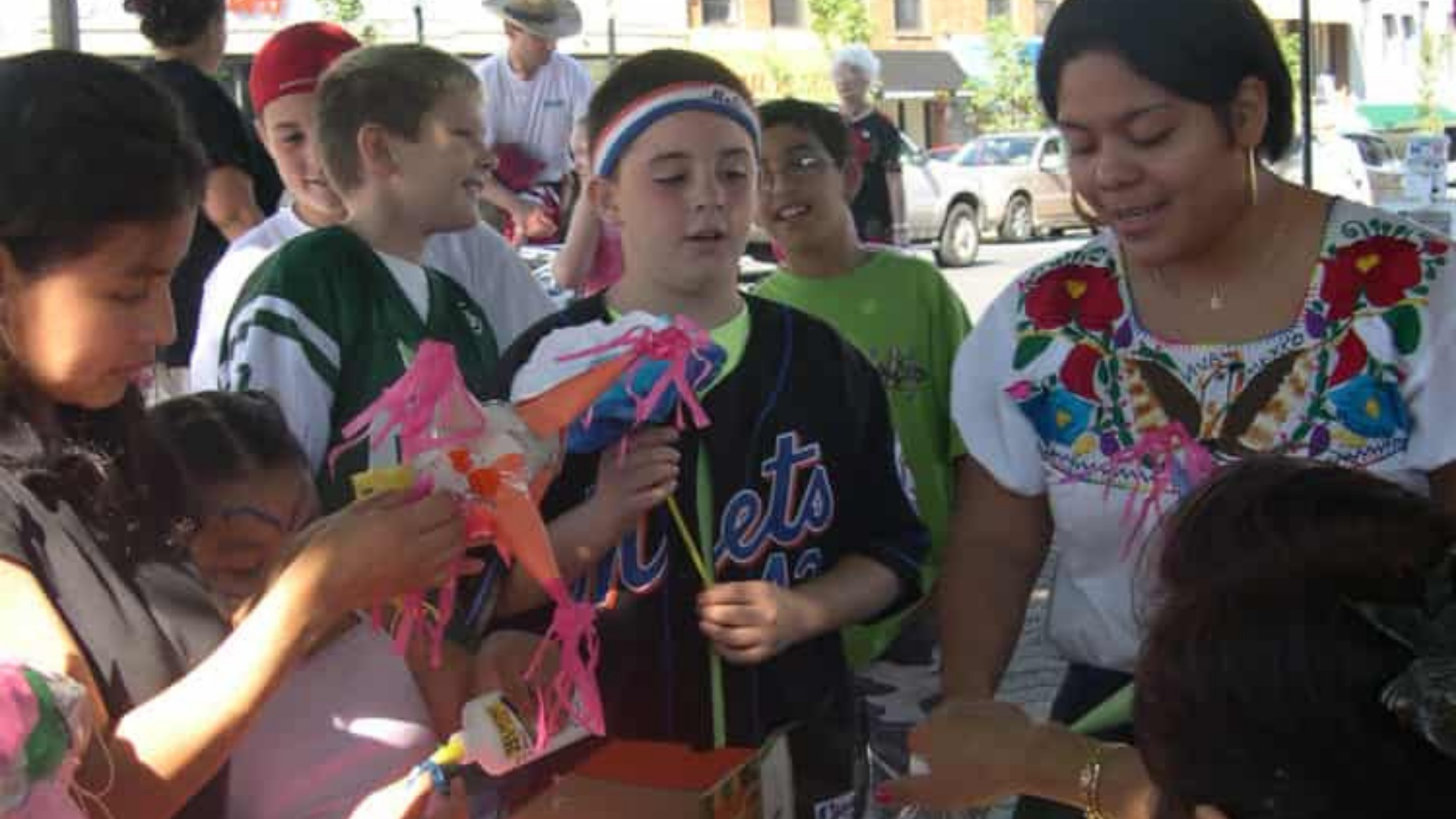 American Folklore Society. Image shows woman showing craft to children.