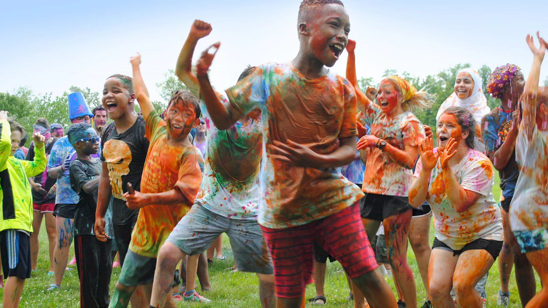 Flying Horse Farms. Image shows children jumping up and down excitedly. They are covered in paint.