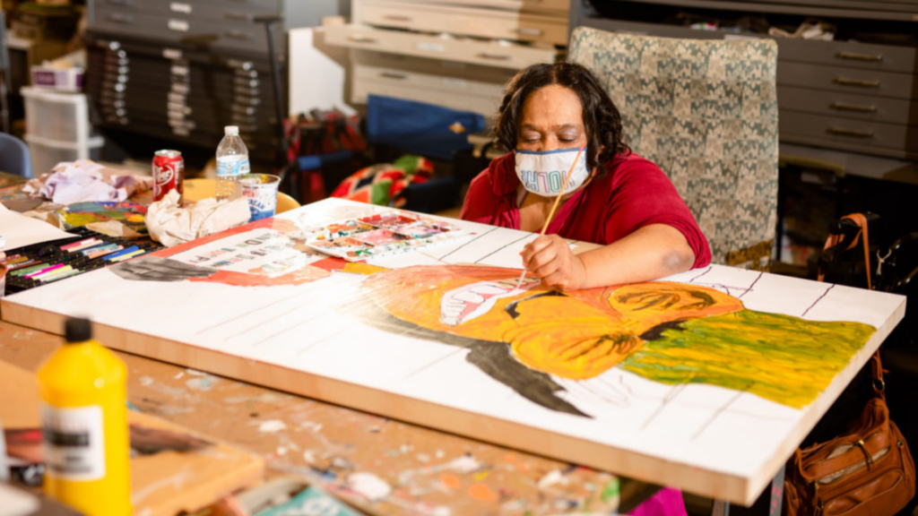 Goodwill Columbus. Image shows a woman painting.
