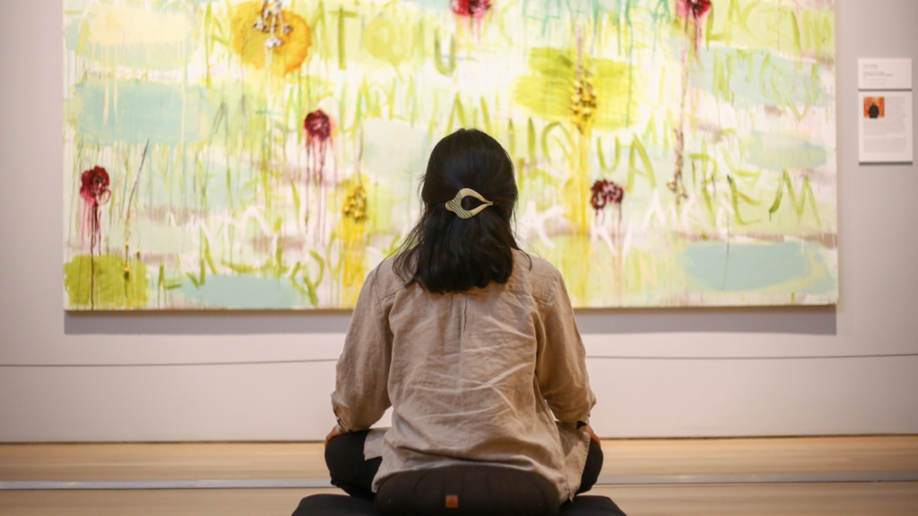 Grand Rapids Art Museum. Image shows a woman sitting in front of an art piece.