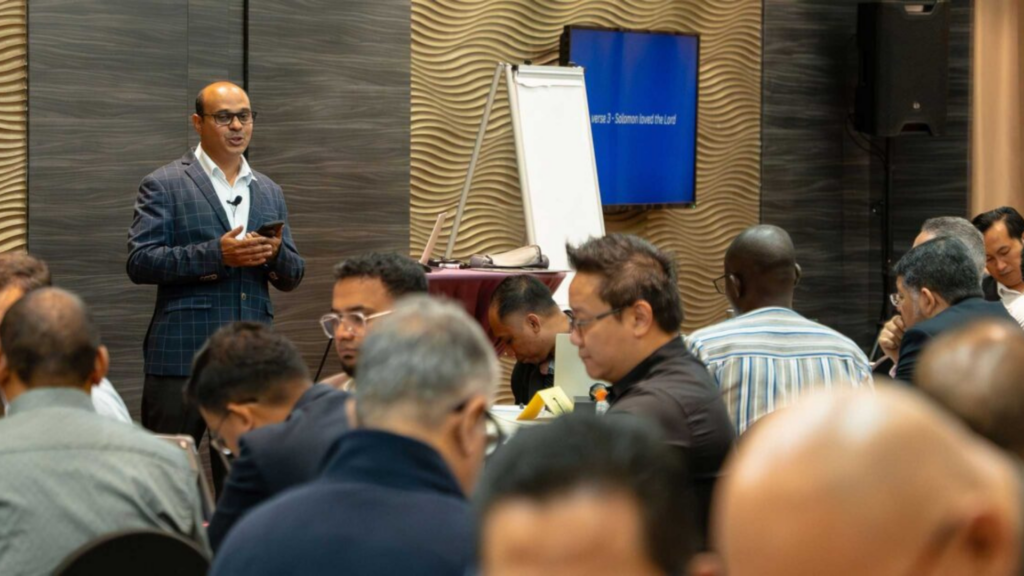 Haggai International. Image shows man presenting to crowd.