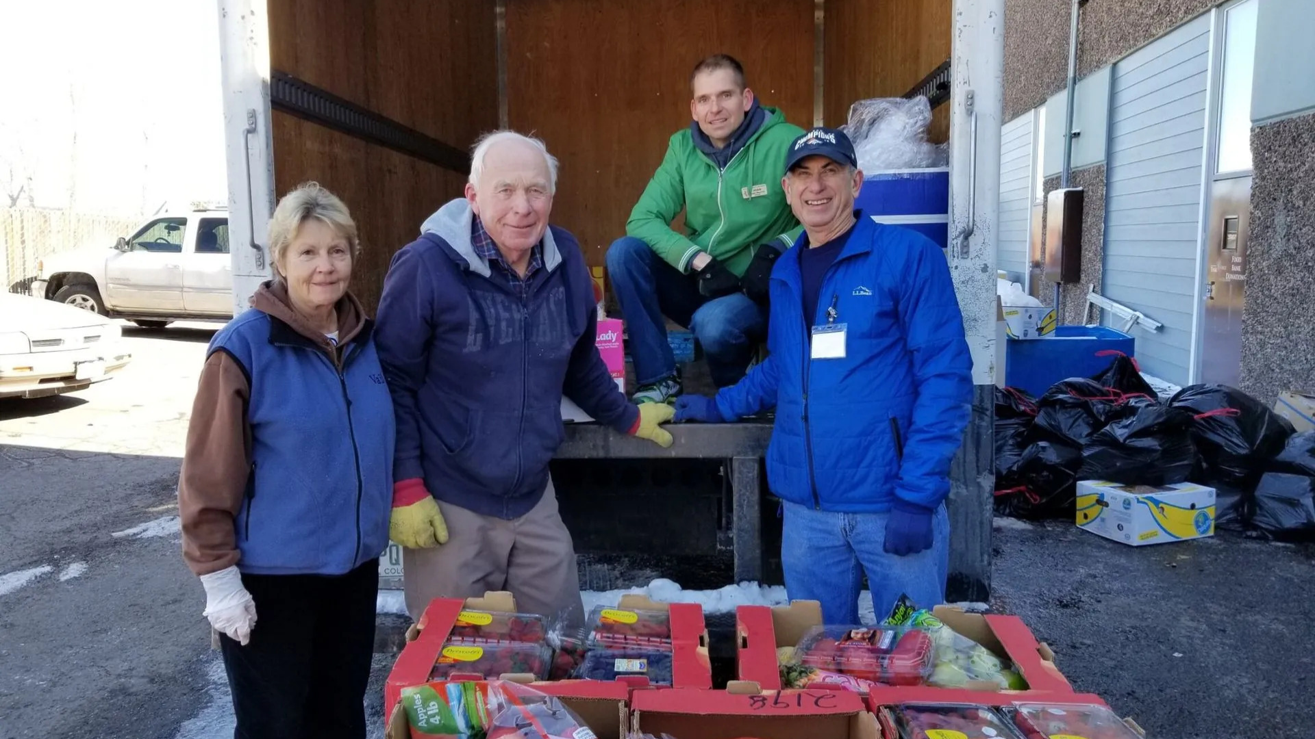 Help & Hope Center. Image shows group of people loading food into a truck.