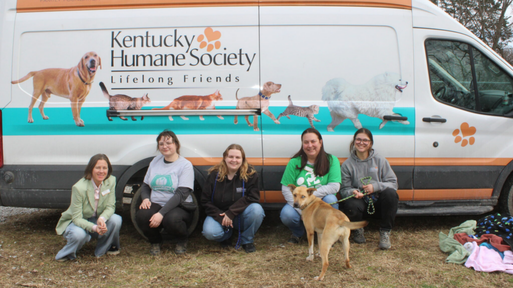 Kentucky Humane Society team with dog in front of transportation van.