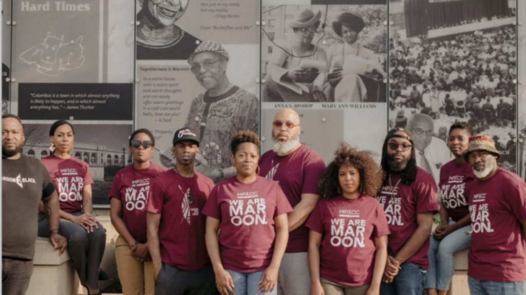 Maroon Arts Group team picture in front of photo mural.
