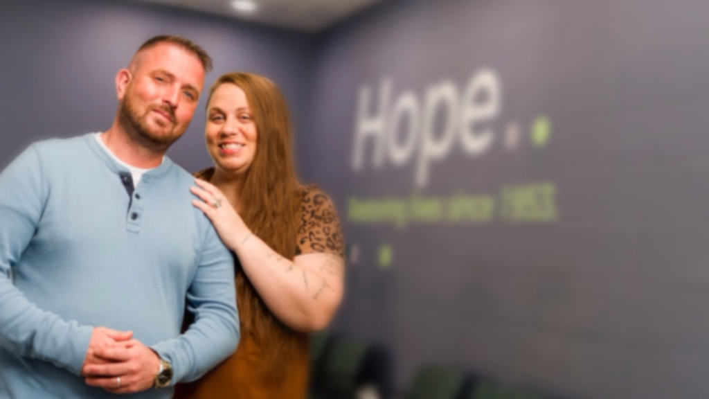 Maryhaven. Image shows two people smiling in front of wall that reads 'Hope.'