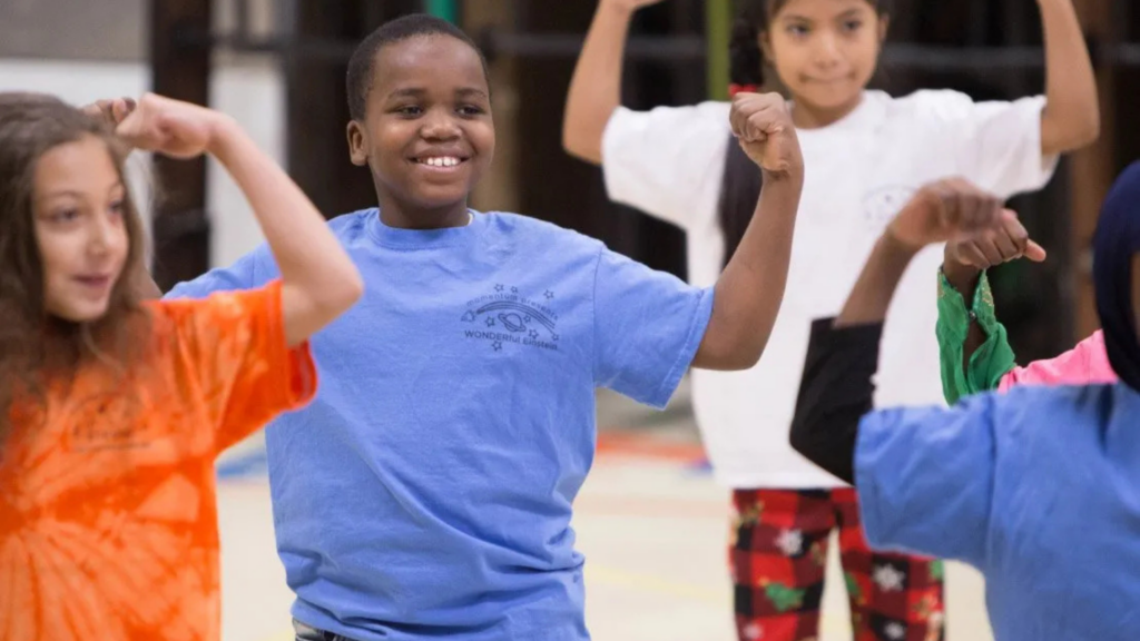 Momentum-Excellence at the Speed of Dance. Image shows children smiling and flexing.