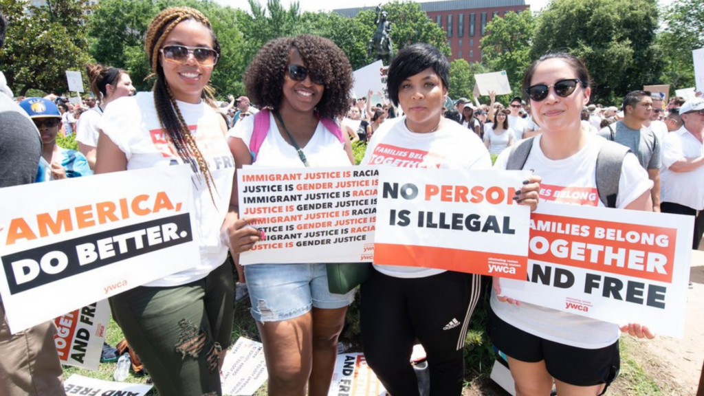 YWCA of Greater Cincinnati. Image shows protesters smiling and holding signs.